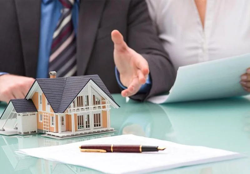Người mua nhà đọc và ký bộ hợp đồng mua bán căn hộ tại sàn giao dịch