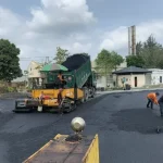 Máy lu đang lu lèn thảm nhựa trên trục đường nội khu phân khu A Vịnh Tiên